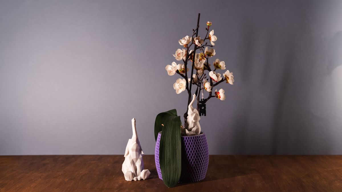 Vaso viola a trama romboidale con un elefante low-poly bianco accanto